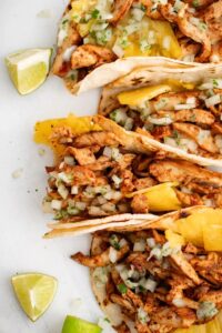 Enjoy the bold flavors of Chicken Al Pastor, marinated in pineapple and spices, grilled to perfection, and served with caramelized pineapple and warm tortillas