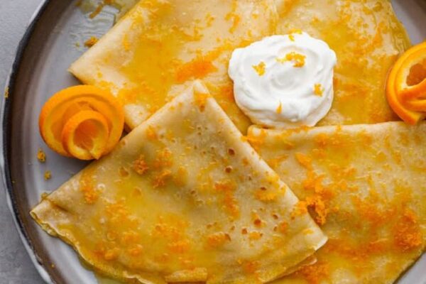 Discover how to make classic Crêpes Suzette at home with this easy recipe! Flambéed in a zesty orange sauce, these crêpes are a delightful treat.